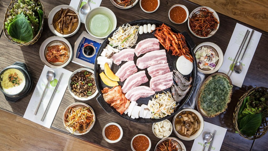 サムギョプサルとおかずが並ぶ韓国の食卓